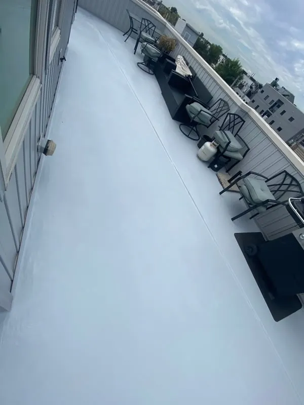 White waterproof coating freshly applied to a Philadelphia flat roof